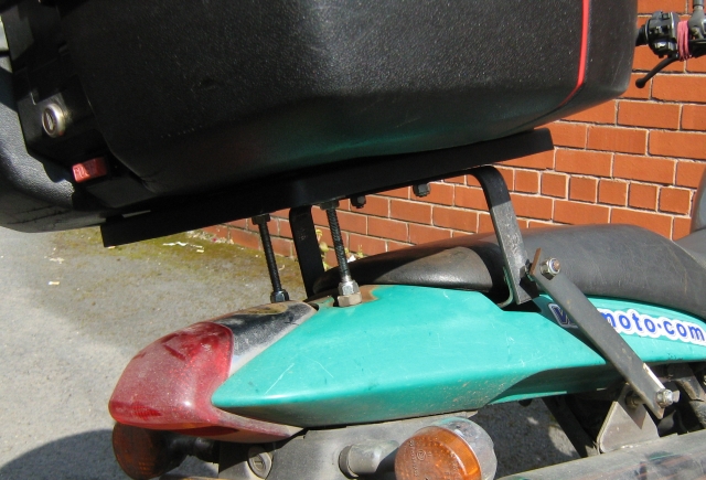 bits of metal and bolts to hold givi rack in place